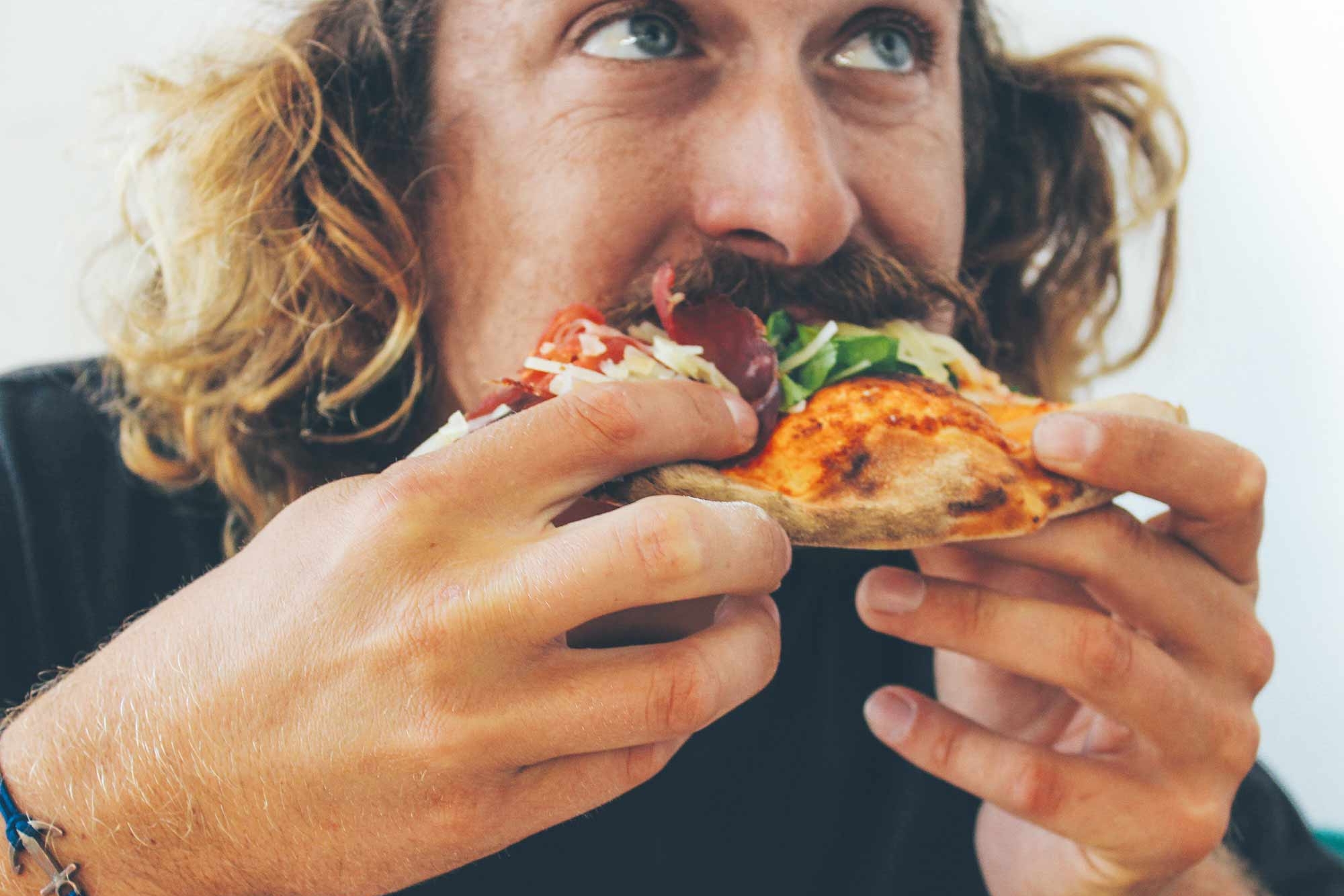 Mann beim Essen einer Pizza in der Mensa Stellingen