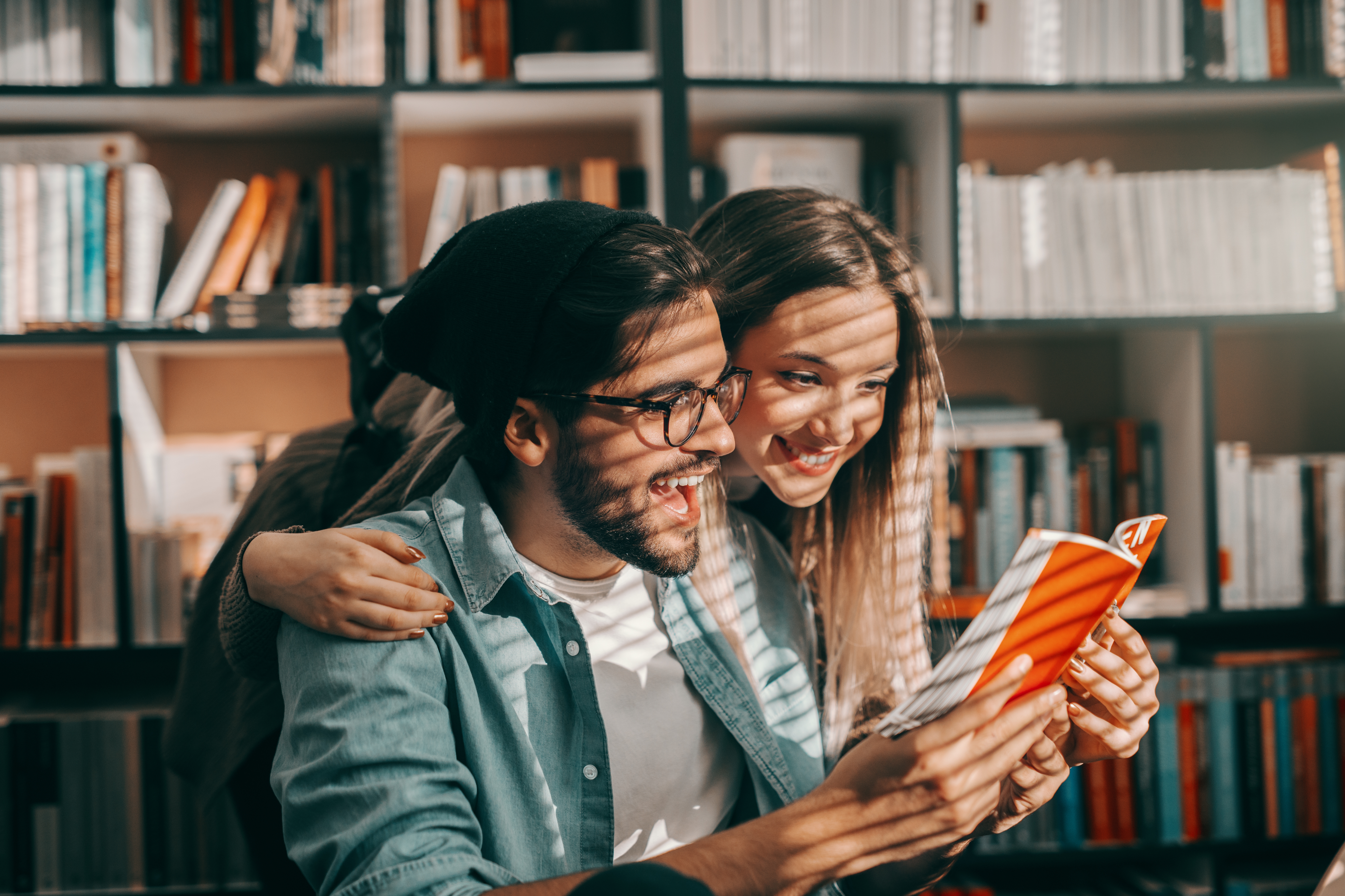 Junge Frau und Mann schauen gemeinsam in ein Buch