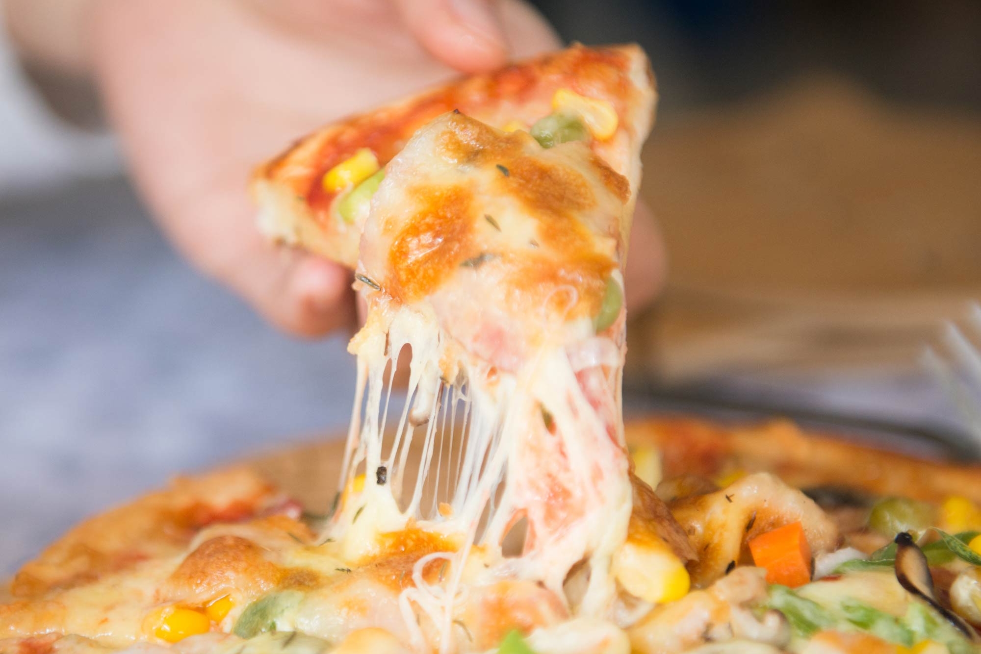 Stück Pizza in der Hand