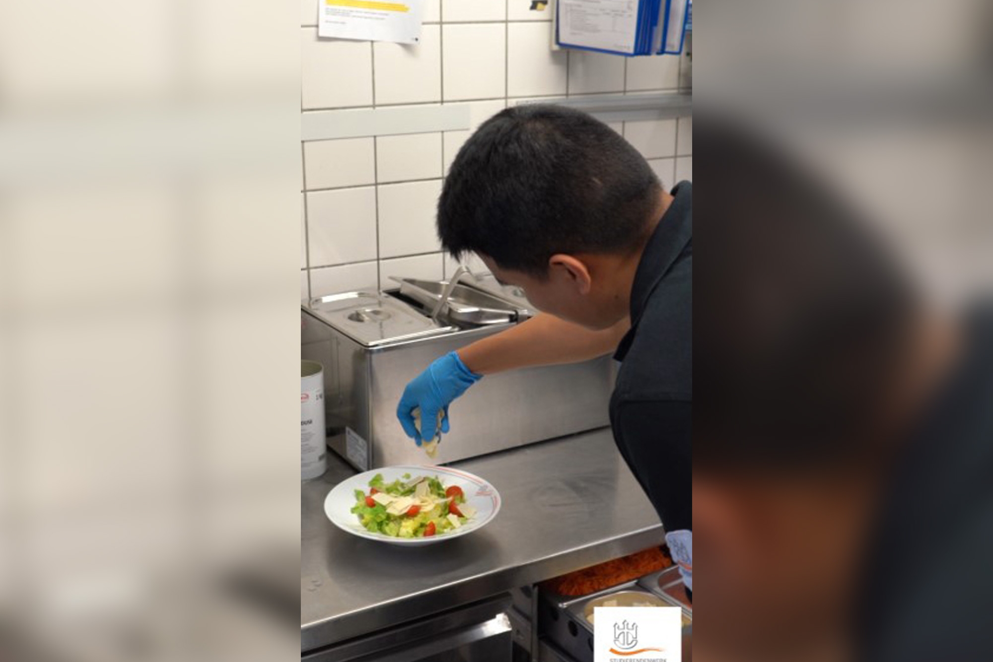 Auszubildender zur Fachkraft Küche beim Anrichten eines Tellers