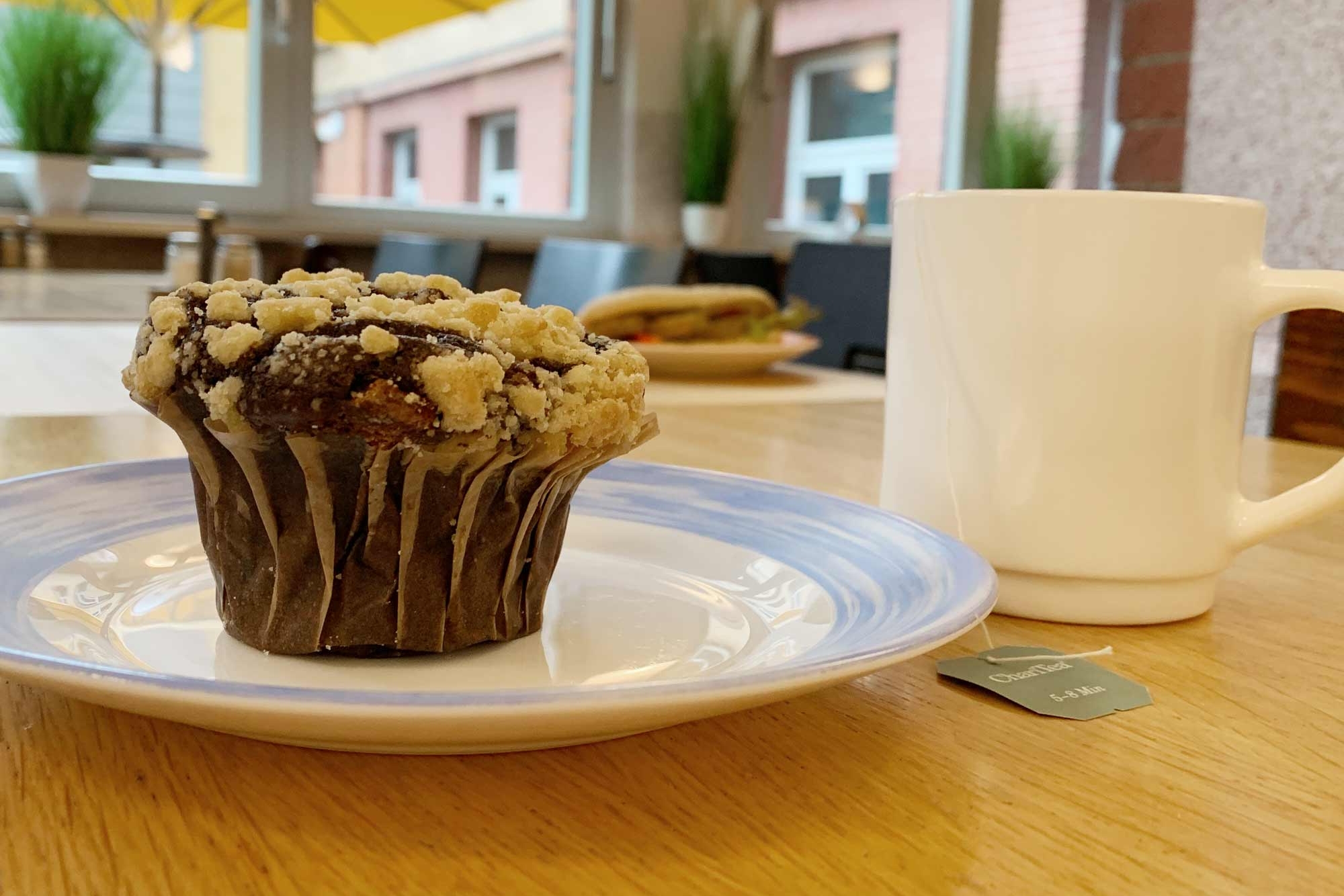 Muffin auf Teller und eine Tasse Tee im Café Jungiusstraße