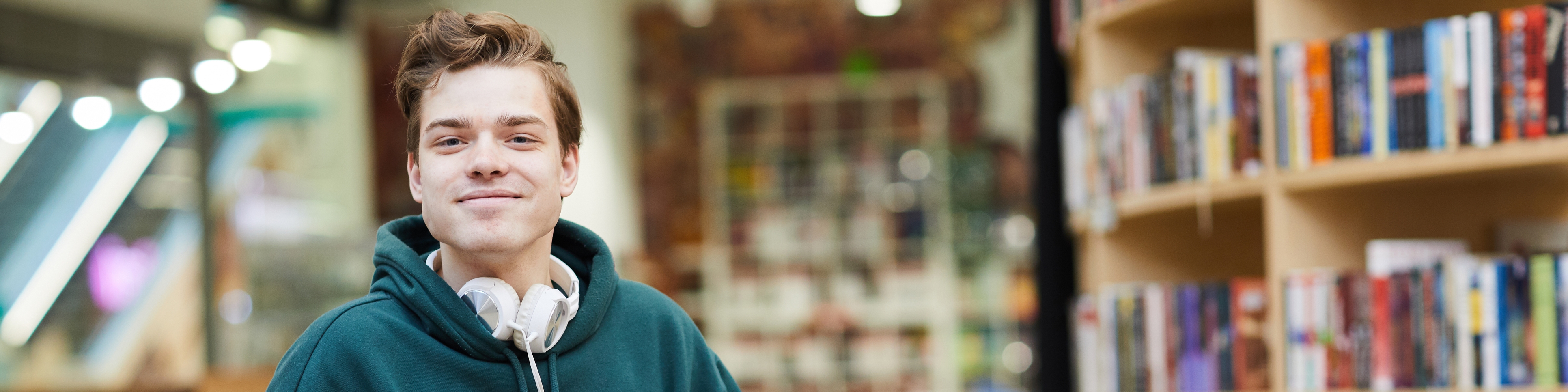 Ein Student im Rollstuhl vor einem Bücherregal