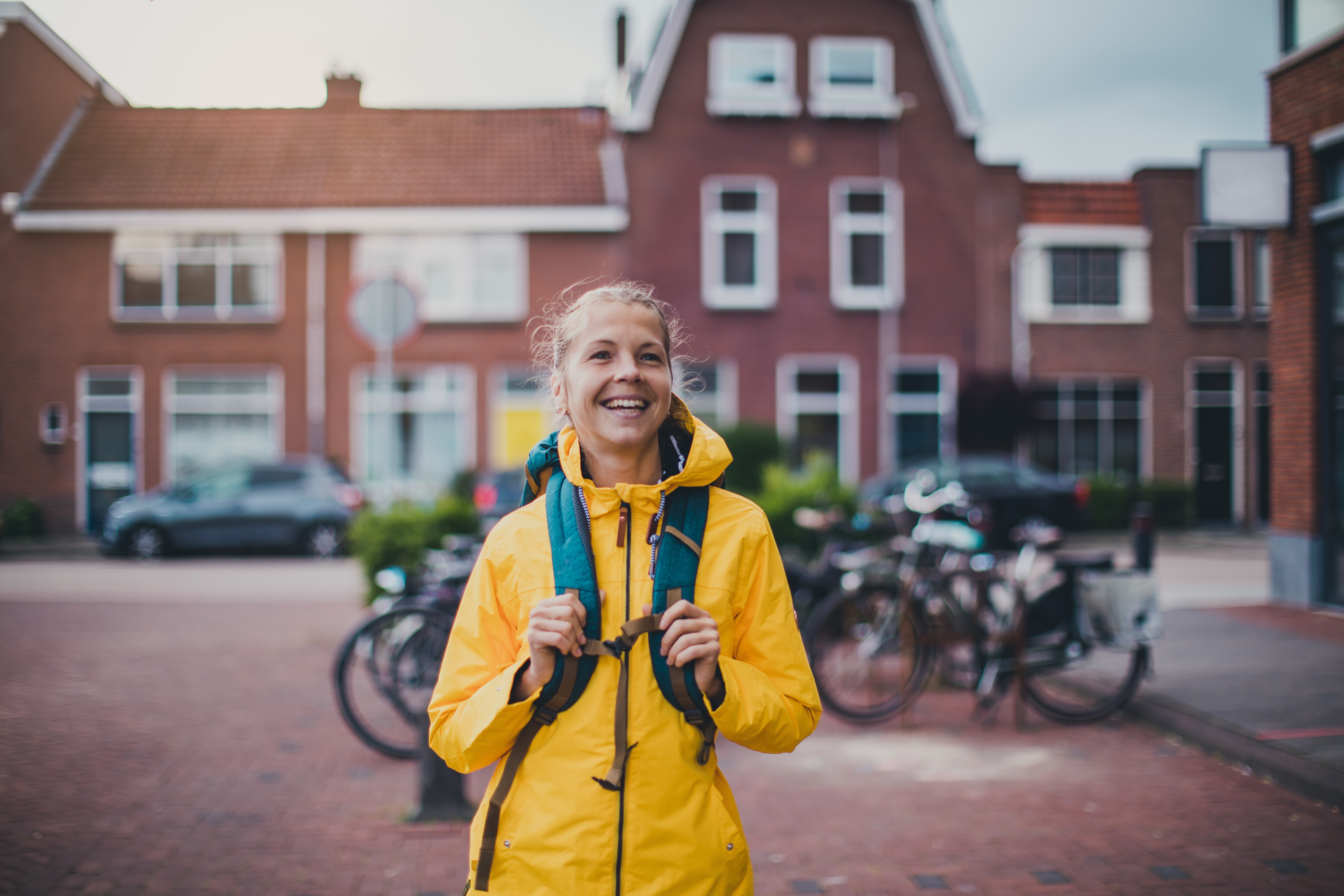 Studentin mit gelber Regenjacke und Rucksack Studentin mit gelber Regenjacke und Rucksack