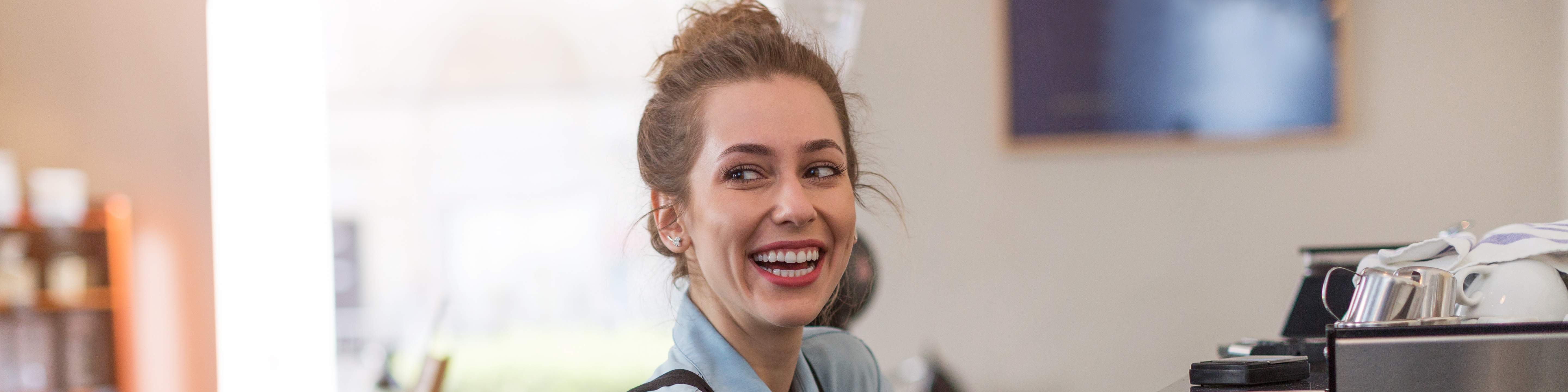 Junge Frau bei der Kaffeezubereitung in einem Café