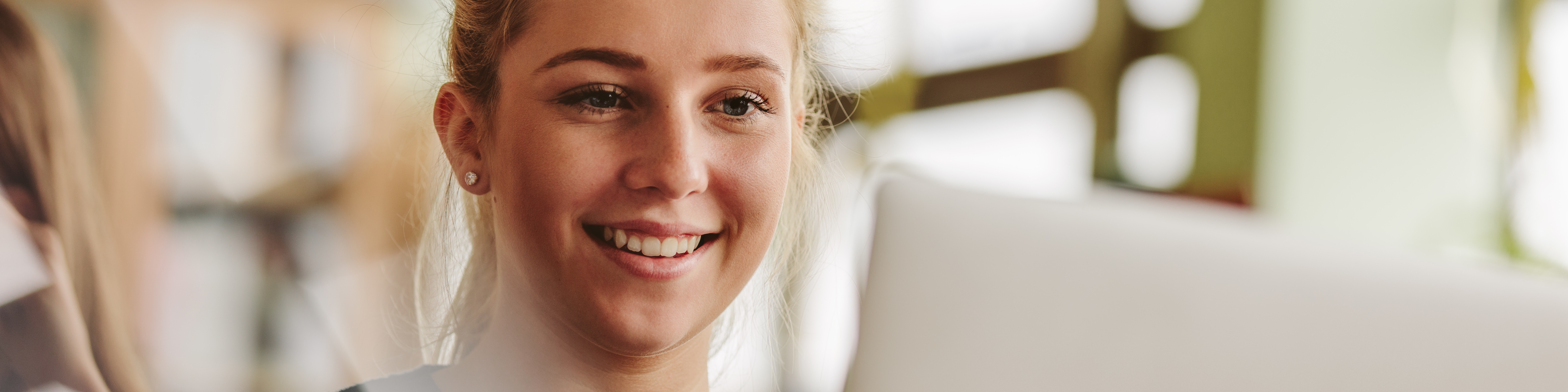 Junges Mädchen sitzt vor einem Laptop