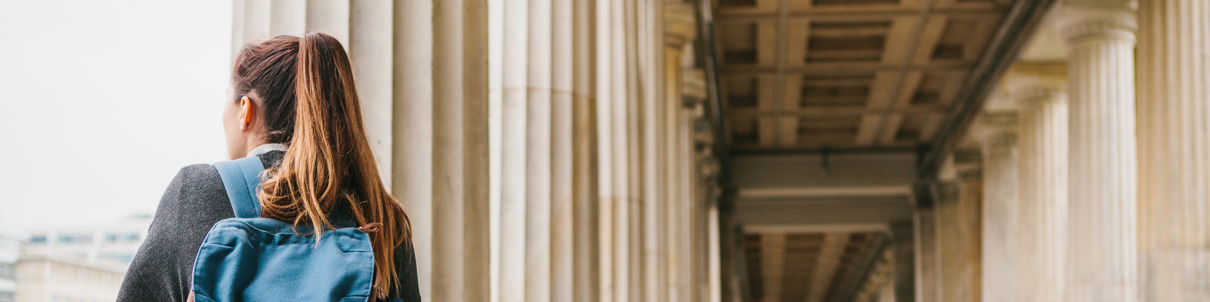 Studentin mit Rucksack auf Stadt blickend
