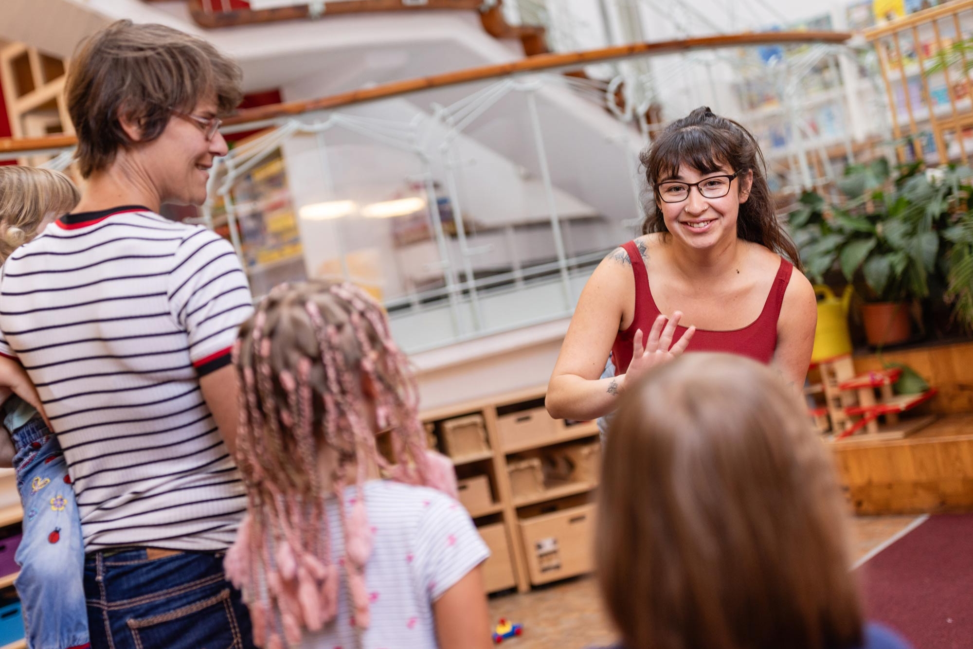 Zwei Erzieher:innen sprechen mit Kindergartenkindern