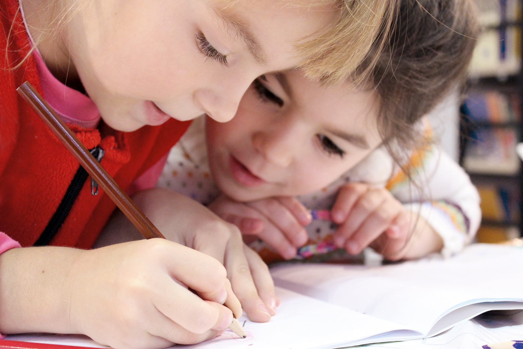 Zwei kleine Mädchen malen gemeinsam ein Bild